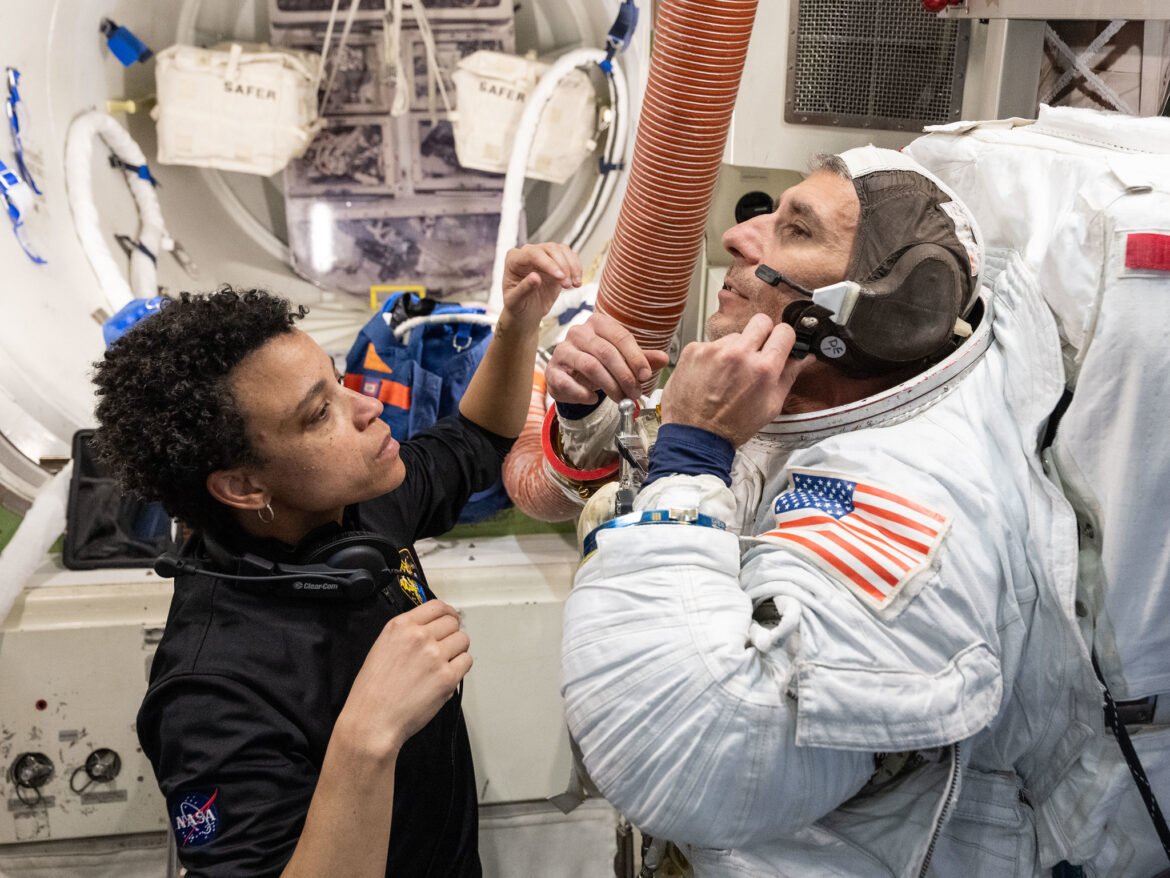 NASA astronaut Jessica Watkins assists NASA astronaut Luke Delaney as he practices suiting up in a spacesuit in an International Space Station airlock simulator on May, 5, 2026, at the agency's Johnson Space Center Space Vehicle Mockup Facility in Houston.
