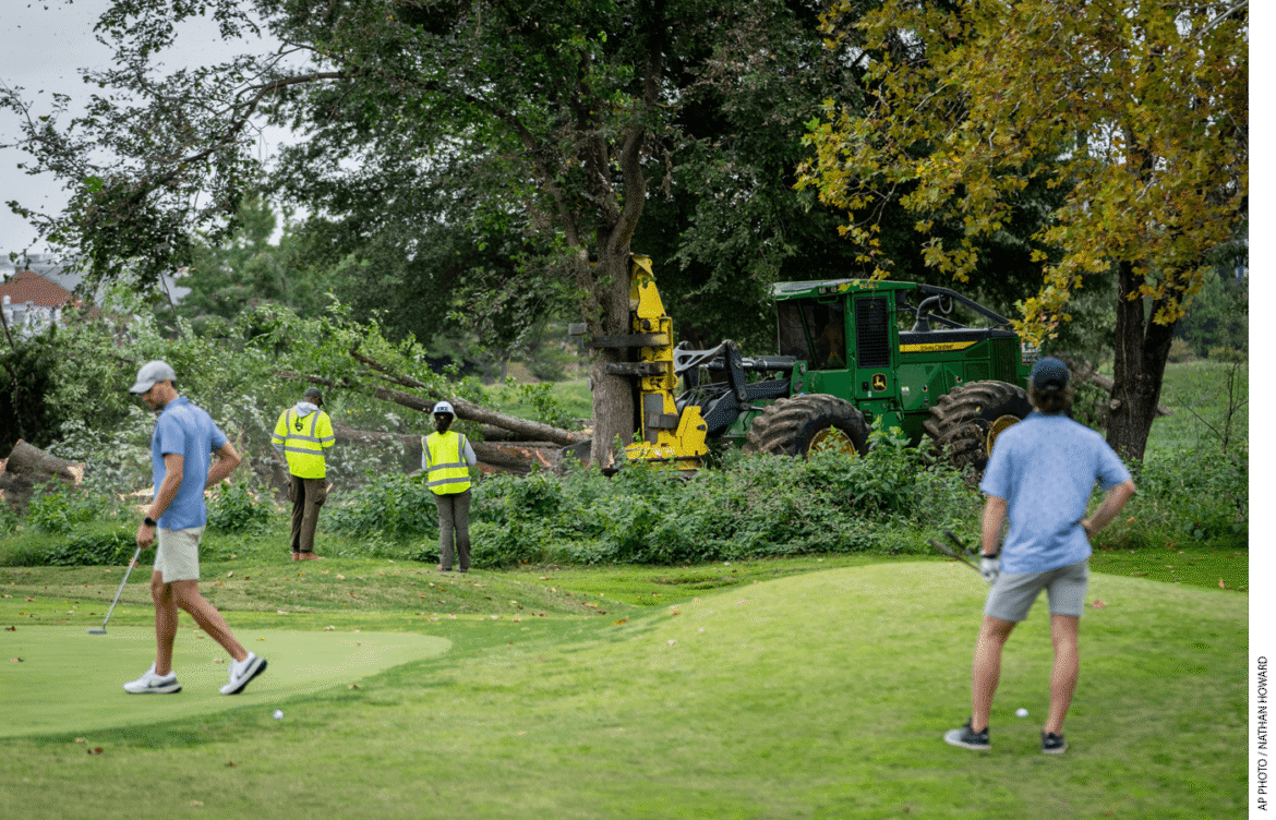 Golfers play through as the National Park Services cuts down trees at the East Potomac Golf Course