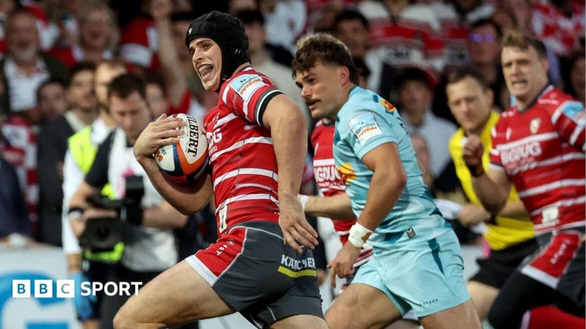 Gloucester's Seb Atkinson carrying the ball in his right hand while looking around before scoring for his side